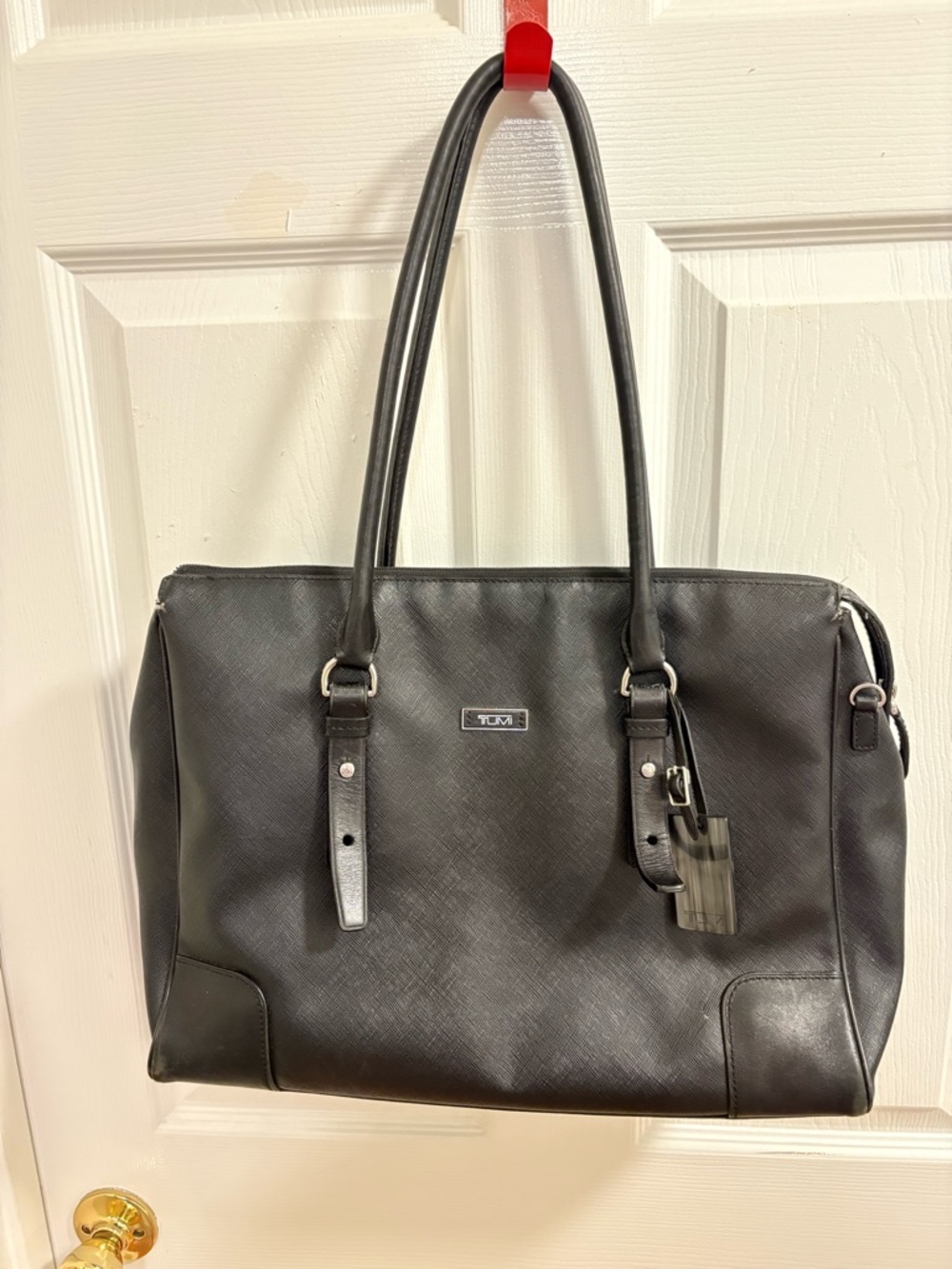 Tumi saffiano leather tote bag in black silver-tone hardware and rolled handles.